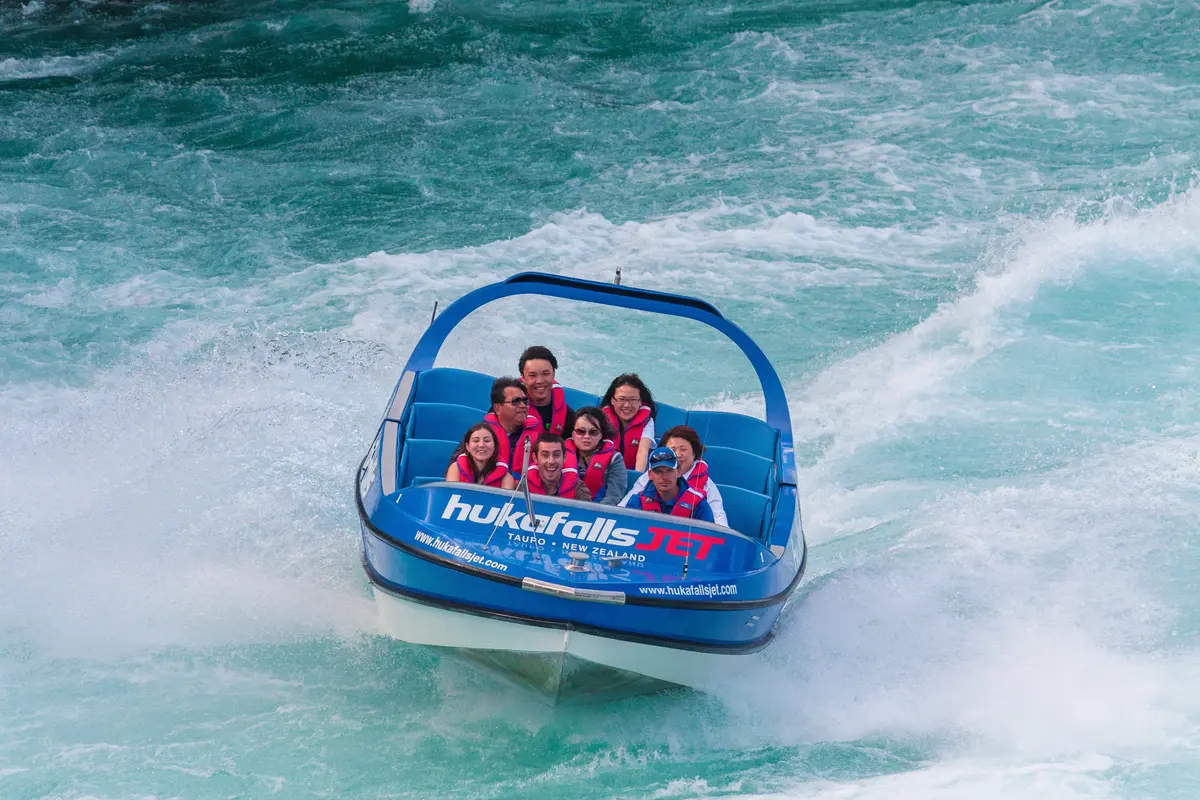Jet boat turning through rapids with guests aboard